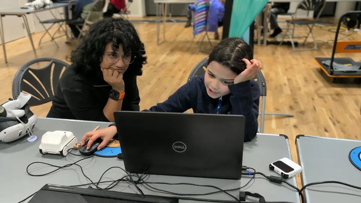 Mentor supporting a young coder at Cambridge